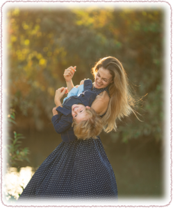 Mother playfully lifting her child outdoors